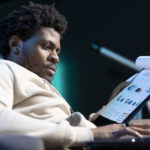 remote accountant transcribing revenue figures from paperwork laptop